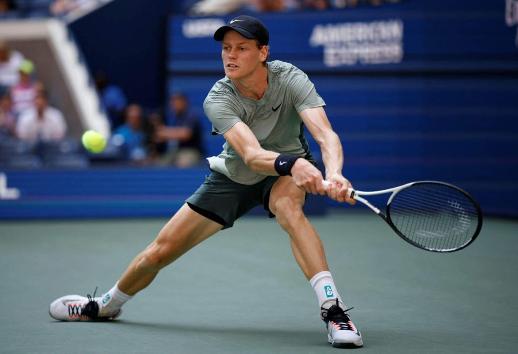 Jannik Sinner, in gray shirt, in action against American Mackenzie McDonald at the US Open