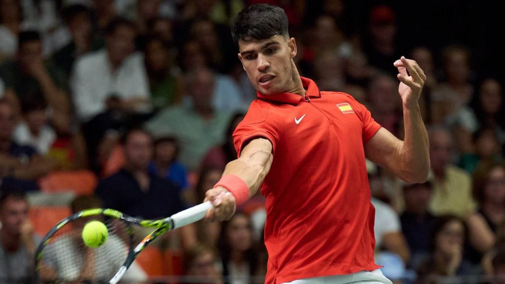 Carlos Alcaraz, in red shirt, returns a shot in this file photo. Alcaraz lauded Rafael Nadal's inclusion in Spain's Davis Cup team