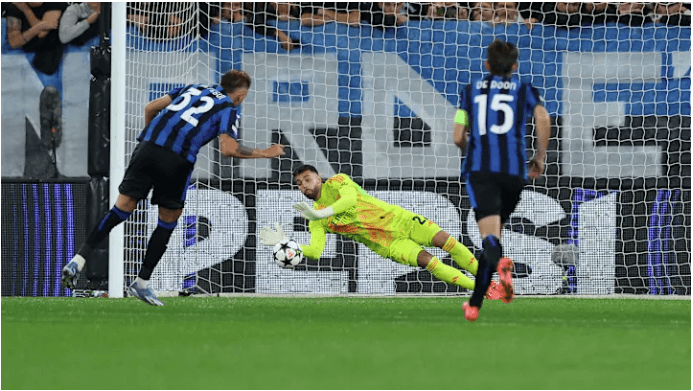 Arsenal goalkeeper David Raya, center, in yellow uniform, catches the ball from reaching the net during the Arsenal-Atalanta match. Managers praised Raya's double save after the match