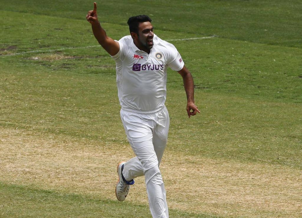 Muttiah Muralitharan, in white uniform, points his finger to the crowd during a match. Muralitharan is concerned on the future of Test cricket format worldwide