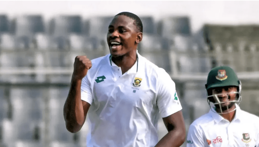 South Africa's Kagiso Rabada, in white shirt and without helmet, pumps his fist as a teammate looks on. Rabada tops Bumrah in ICC Test rankings as top bowler