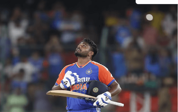 Sanju Samson, in blue and orange uniform, looks in the sky during a lull in India's Test match against Bangladesh. Samson was honored in India for topping Rohit Sharma's T20I record.