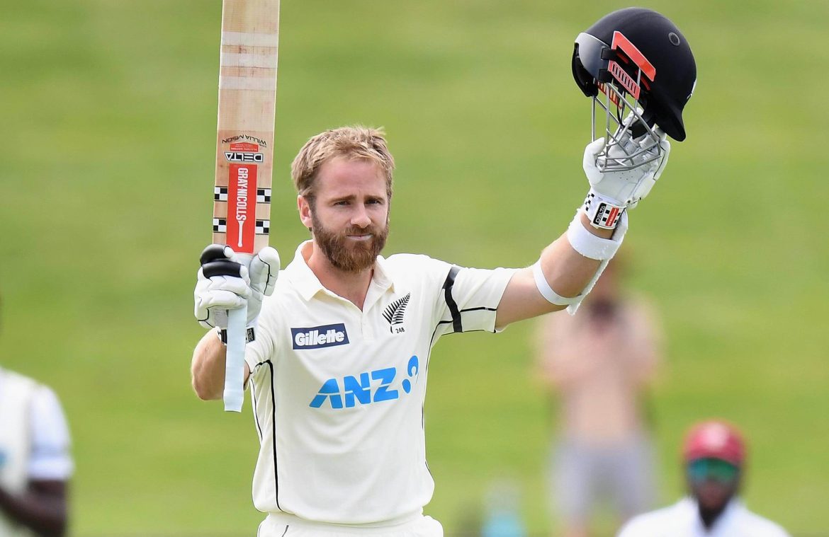 Kane Williamson, in white uniform, gestures during a match break. Williamson will skip the first Test series against India due to a groin strain
