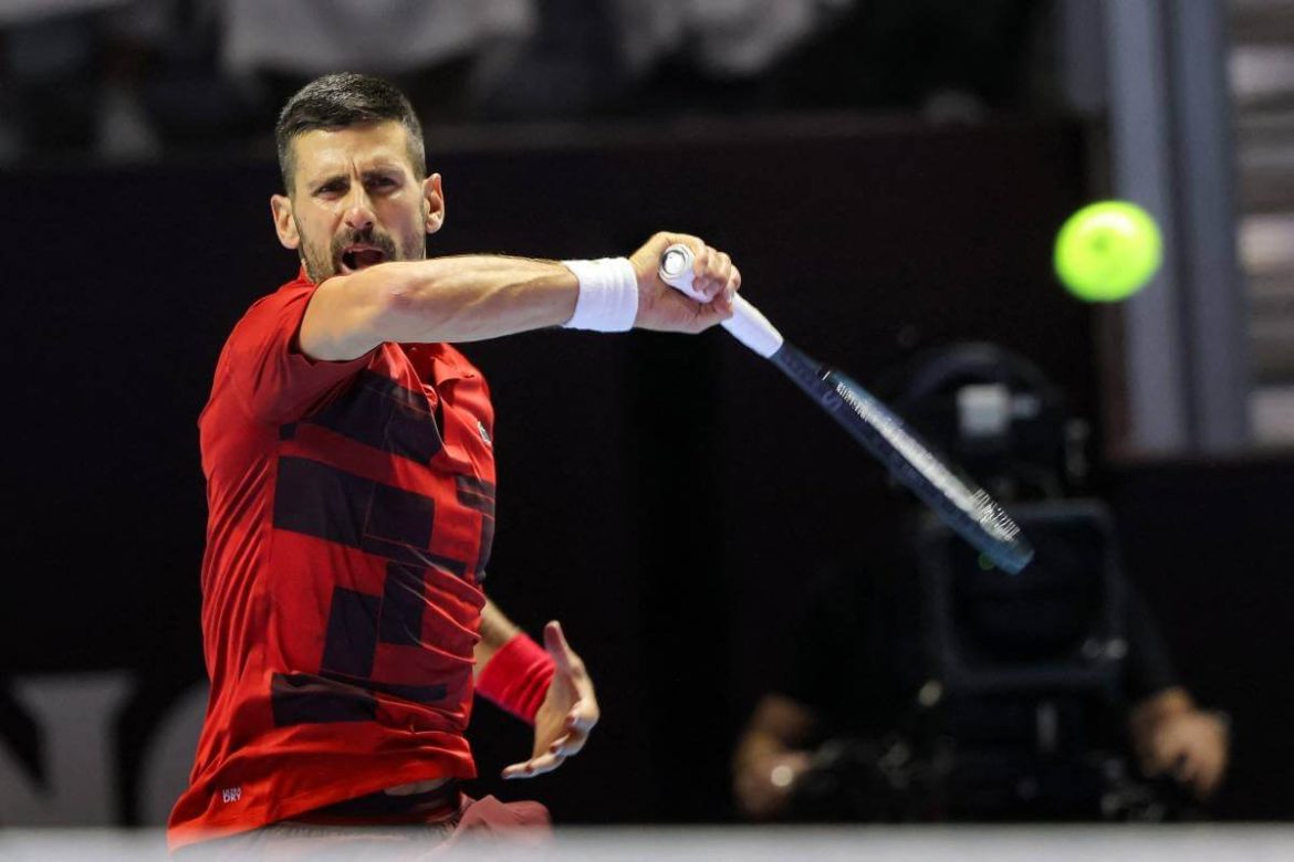 Novak Djokovic, in red shirt and white shorts, in action in file photo. Djokovic to miss ATP Finals due to 'ongoing injury'