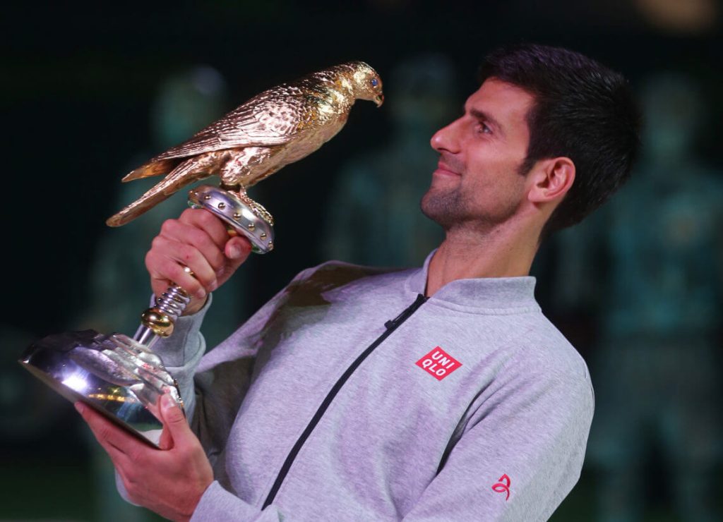 Serbia's Novak Djokovic, in gray shirt, clutches a trophy in file photo. Djokovic to play in Qatar Open weeks after Australian Open