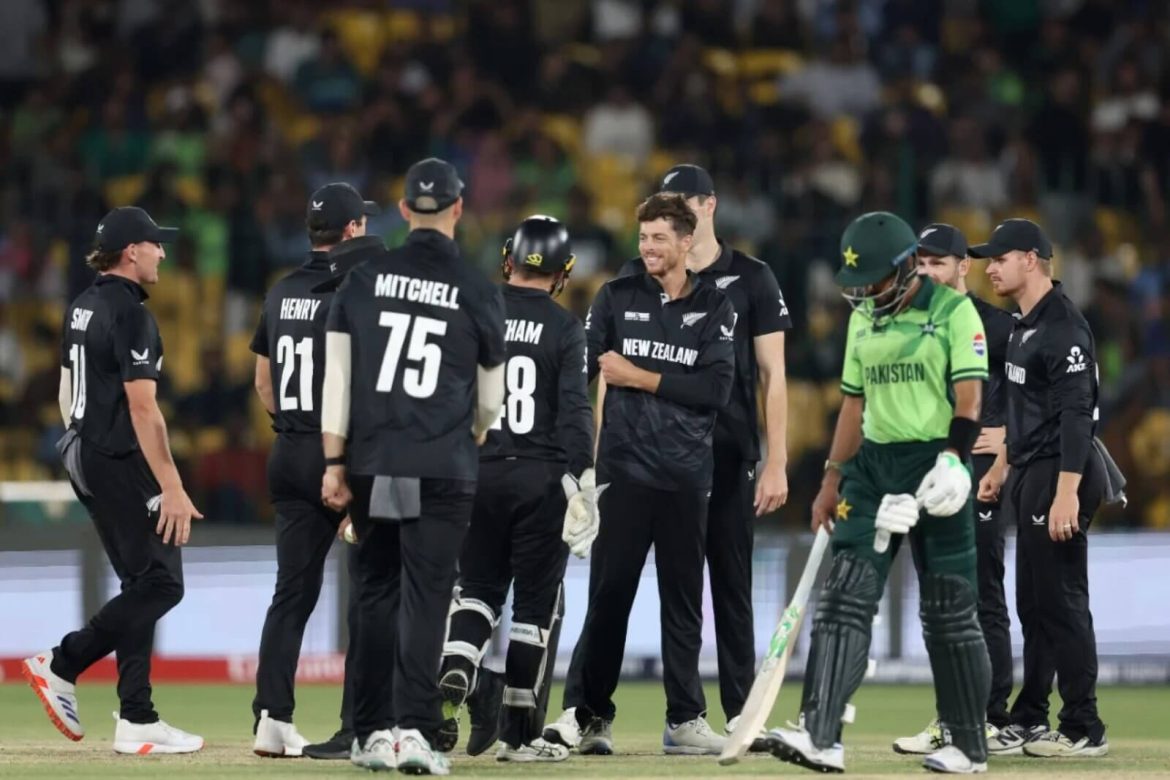 Players from New Zealand (in black) gather in the field while a lone Pakistan cricketer (in green) walks away from the group during the teams' match in Karachi on Wednesday. New Zealand tops Pakistan by 60 runs in Champions Trophy 2025