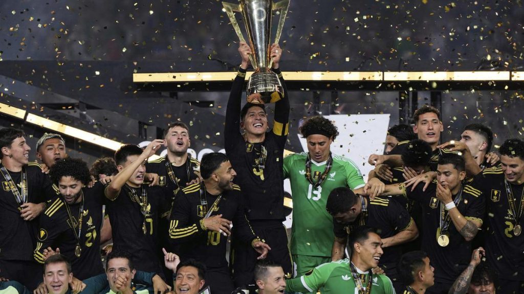 Players and supporters of the Mexico men's football team pose with the trophy after the El Tri beat host United States, 2-1, in the CONCACAF Gold Cup final in Houston on Sunday. Mexico vs USA final has El Tri claim CONCACAF Gold Cup title