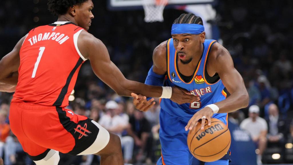 Oklahoma City Thunder guard Shai Gilgeous Alexander (2, right) tries to drive past Houston Rockets guard Amen Thompson (1, left) in the Rockets vs Thunder NBA 2025-26 opening night regularseason match.