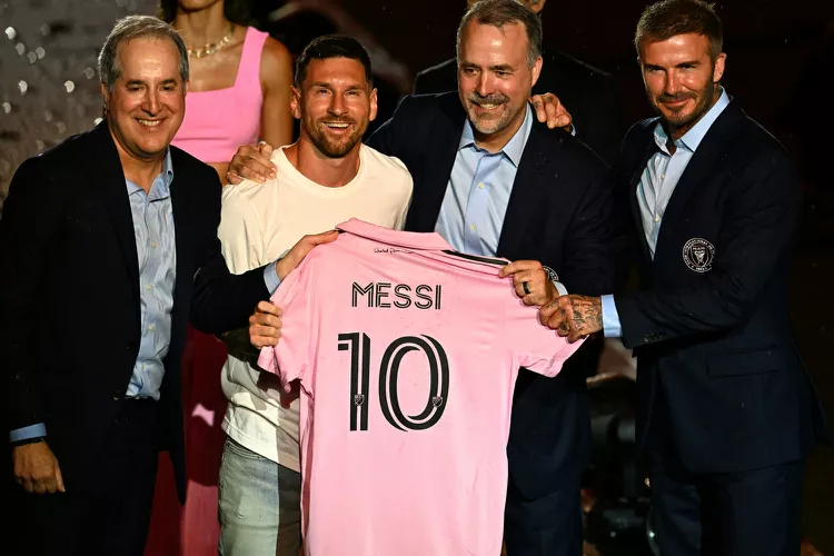 Lionel Messi (in white, second from left) poses with his pink Inter Miami No.10 jersey along with the team's management, including co-owner David Beckham (extreme right) in July 2023.